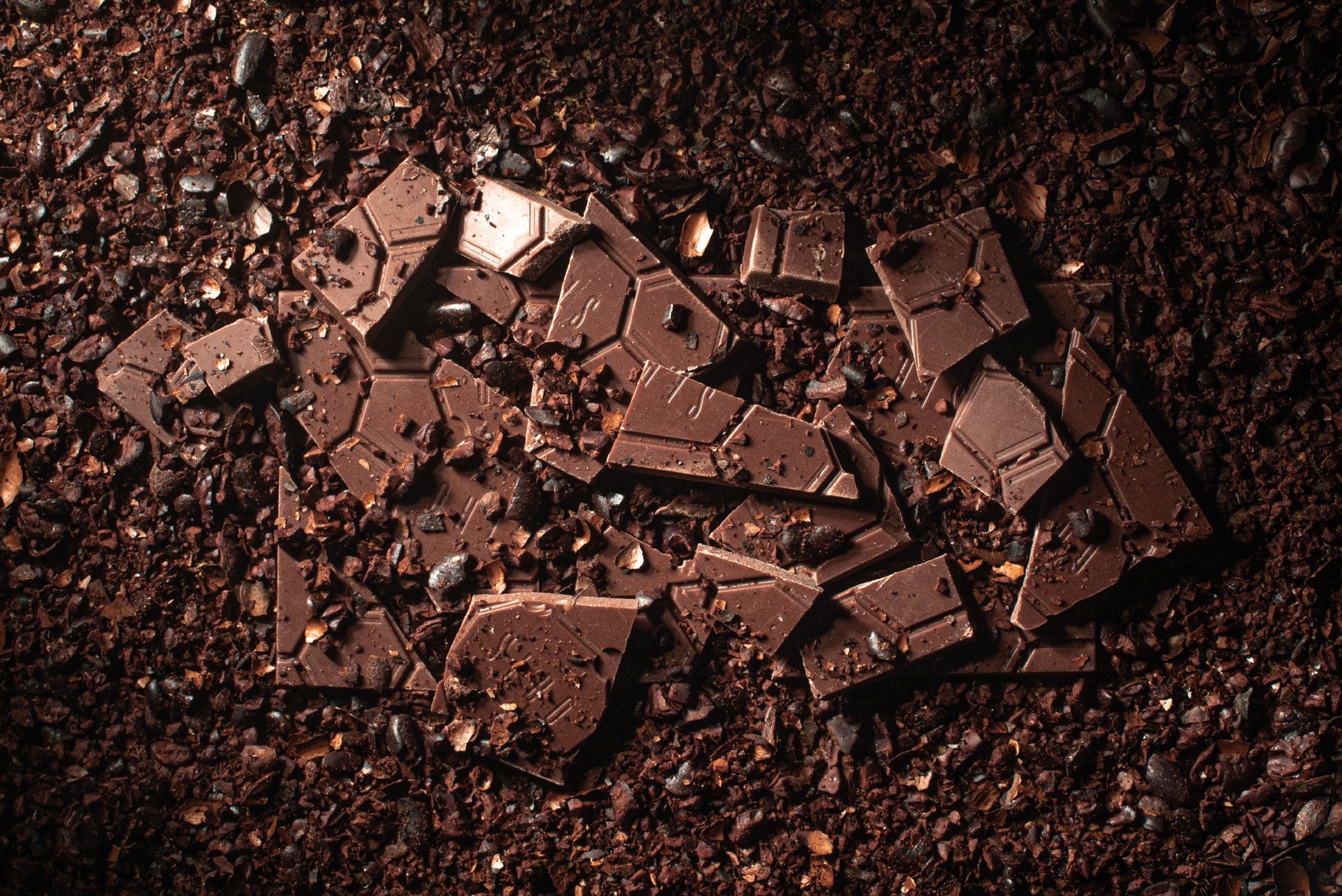 Tempered Guatemalan Chocolate in a fine cacao nibs in background. Highlights the tempering quality.